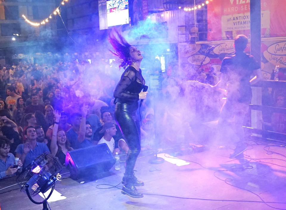 a woman standing on top of a stage in front of a crowd