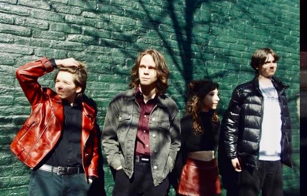 a group of young men standing next to a brick wall