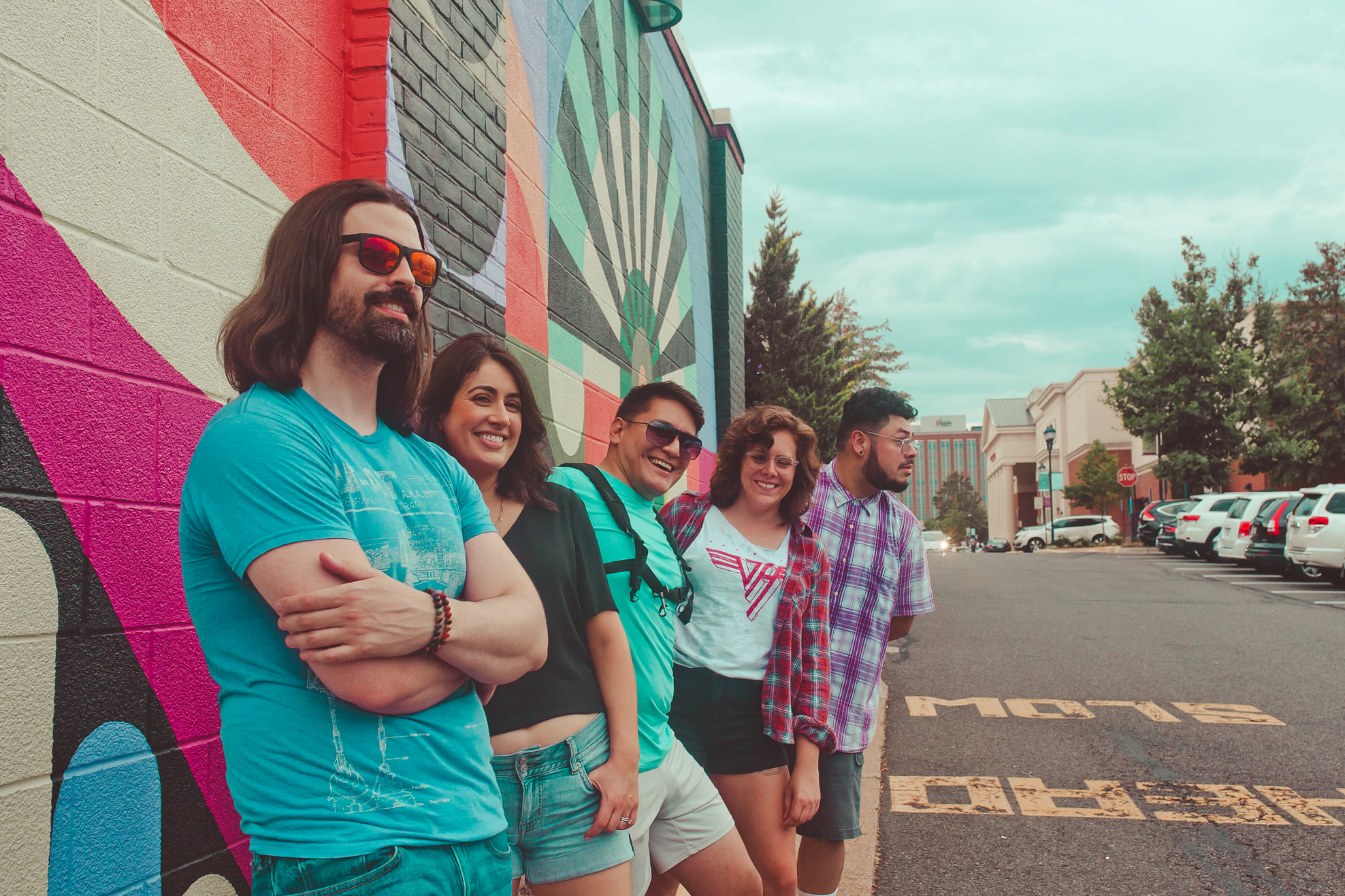 a group of people standing in front of a colorful wall